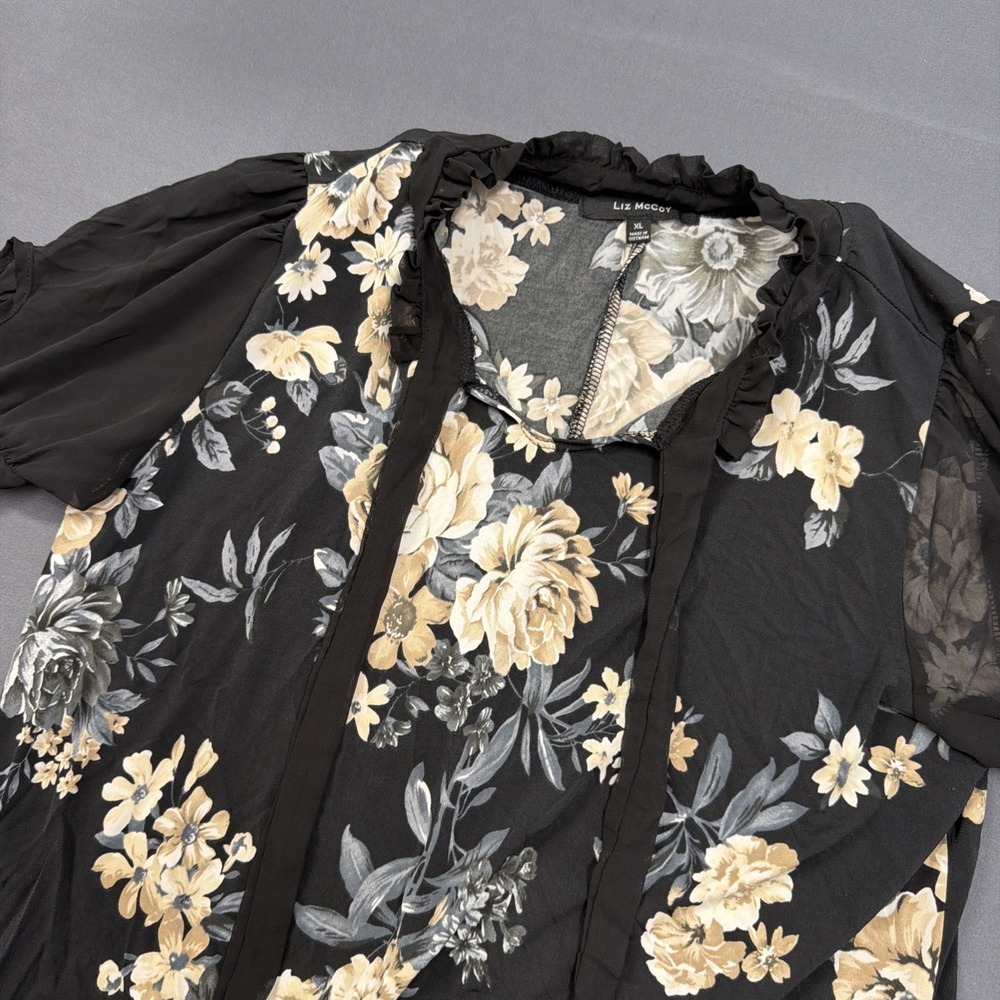 Liz McCoy blouse features a black base with a cream and gold floral‎ print